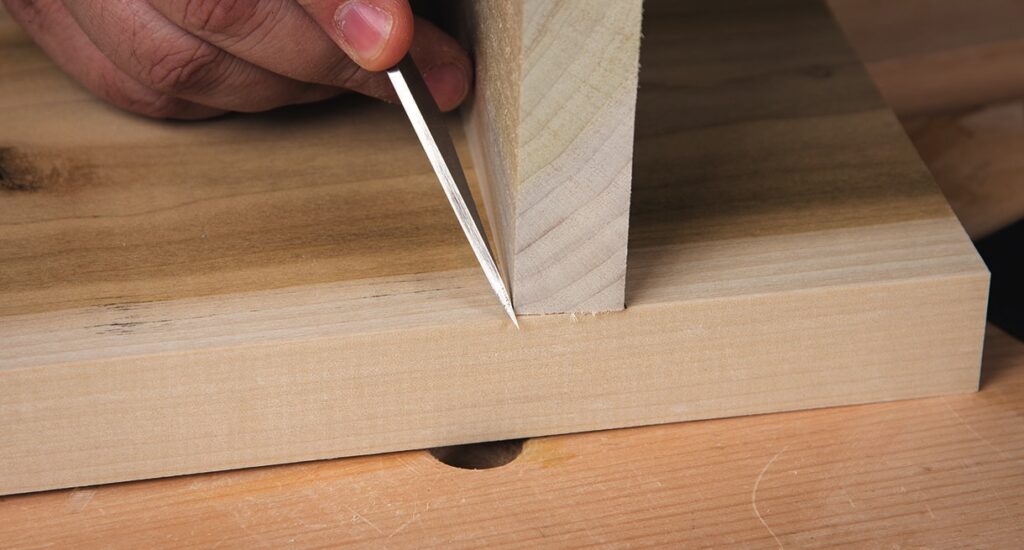 Hand marking wood with a knife for joinery.