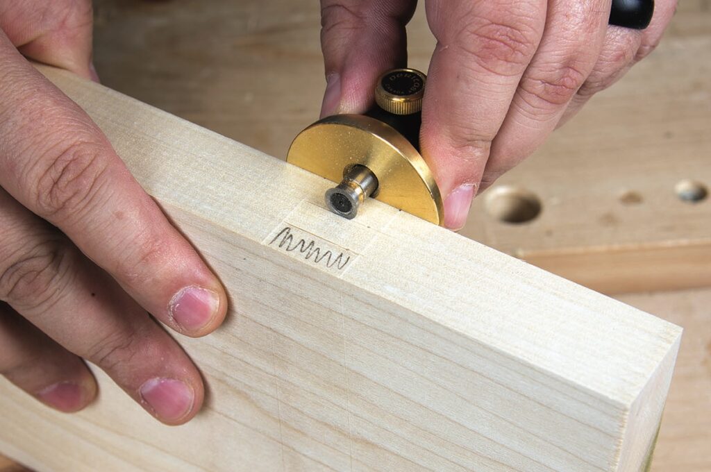 Person using marking gauge on wood