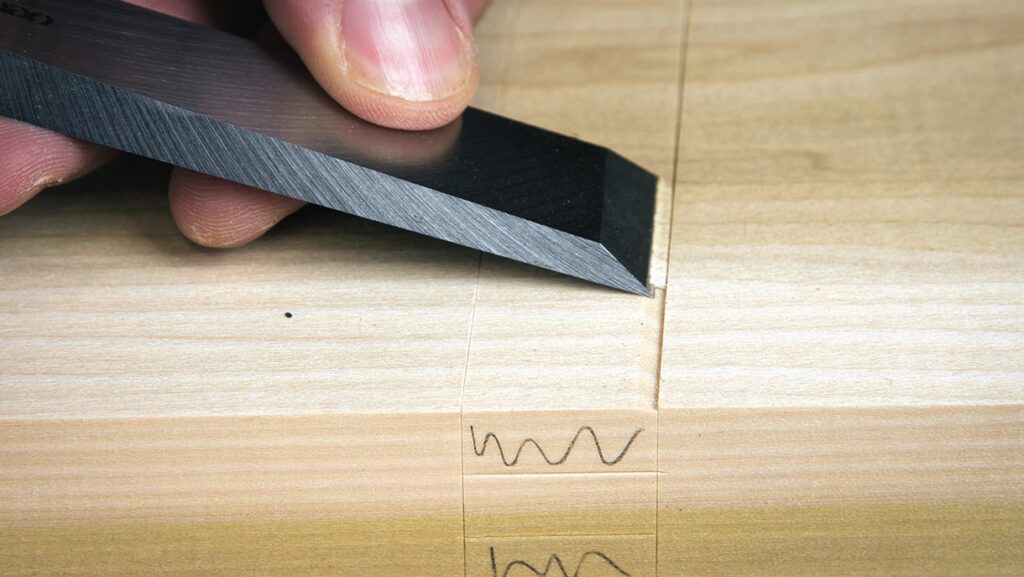 Sharp chisel carving wood piece for joinery work.