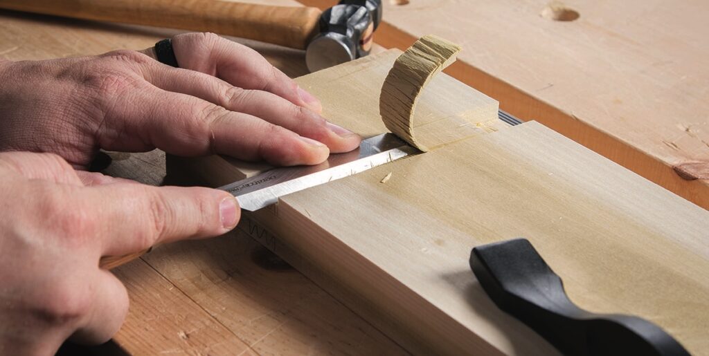 Close-up of hands chiseling wood