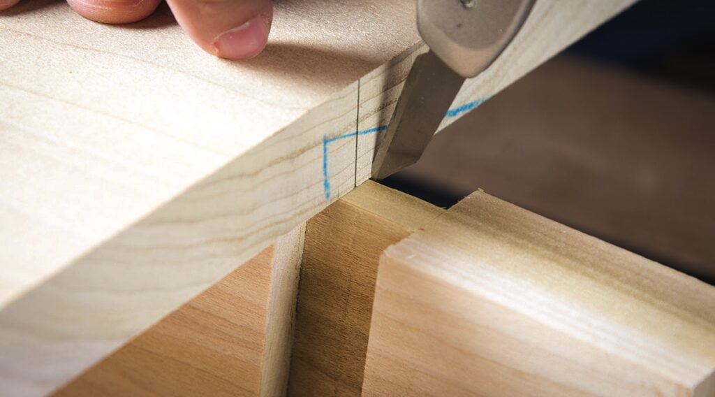 Carving a precise mortise and tenon joint in wood.