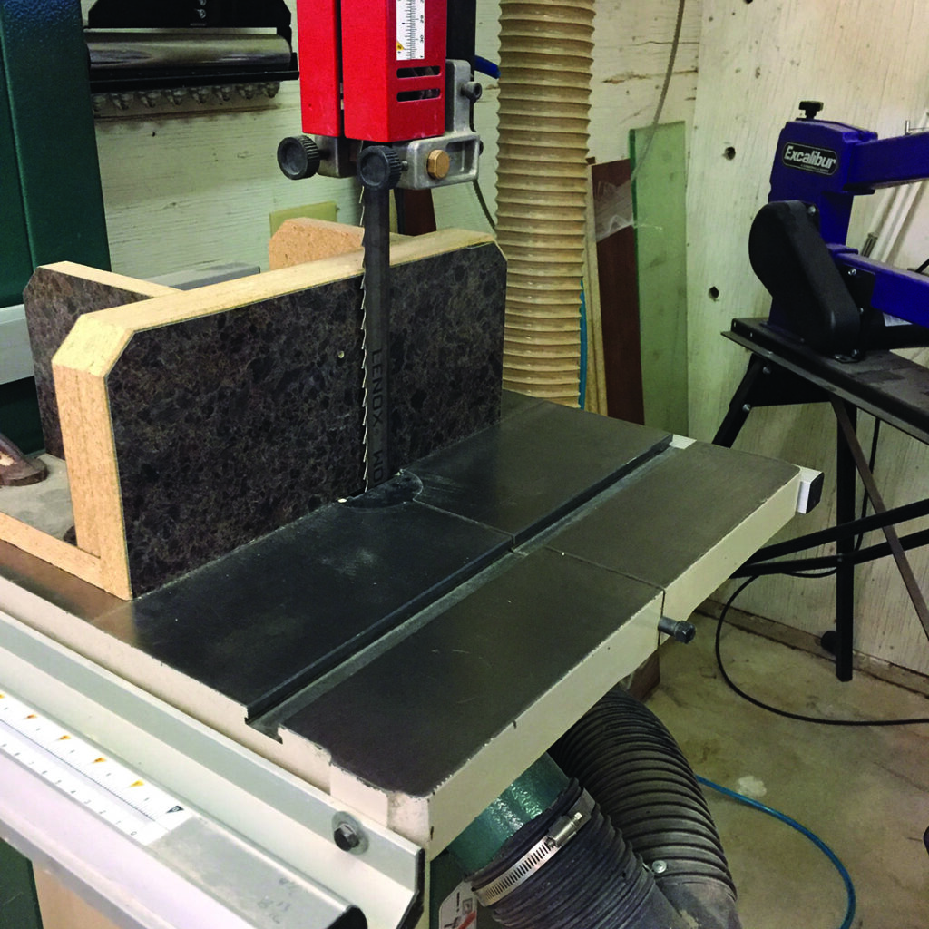 Woodworking bandsaw in workshop setting.