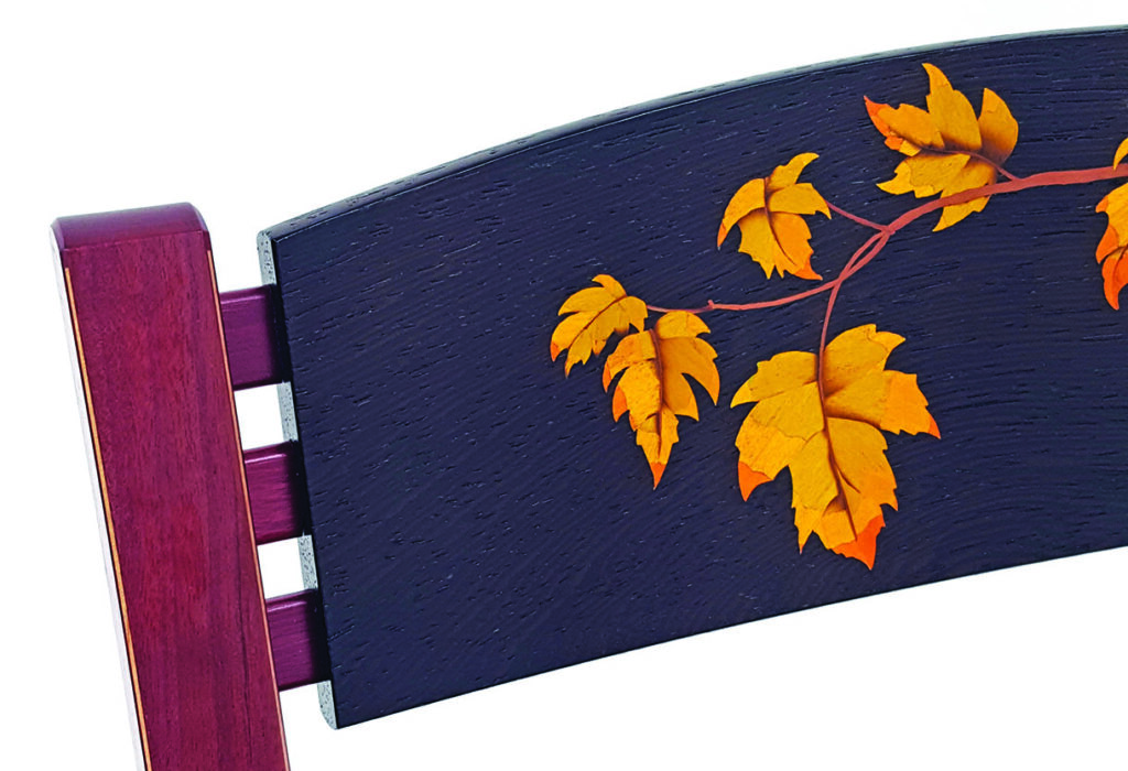 Chair back with painted yellow leaves design.