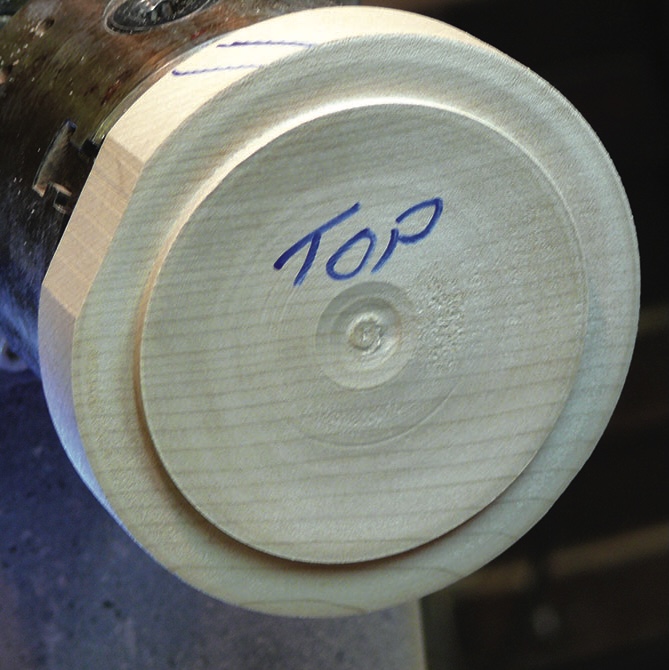 Wooden object labelled 'top' on lathe.