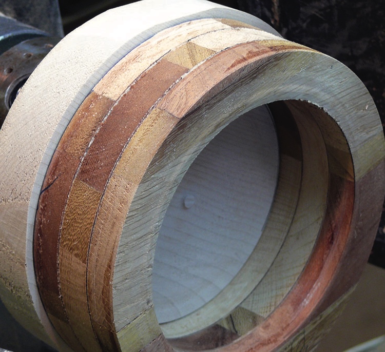 Wooden ring segmented in layers on lathe.