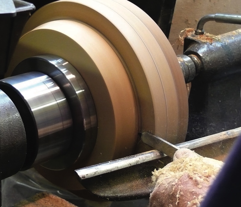 Woodturning on a lathe in action.