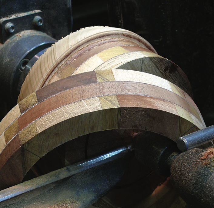 Wooden bowl being shaped on a lathe.