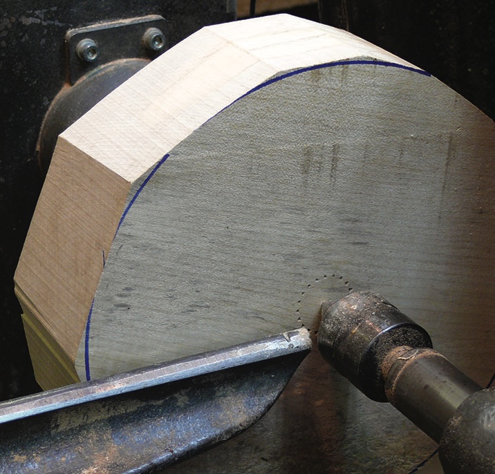 Wood lathe shaping triangular block.