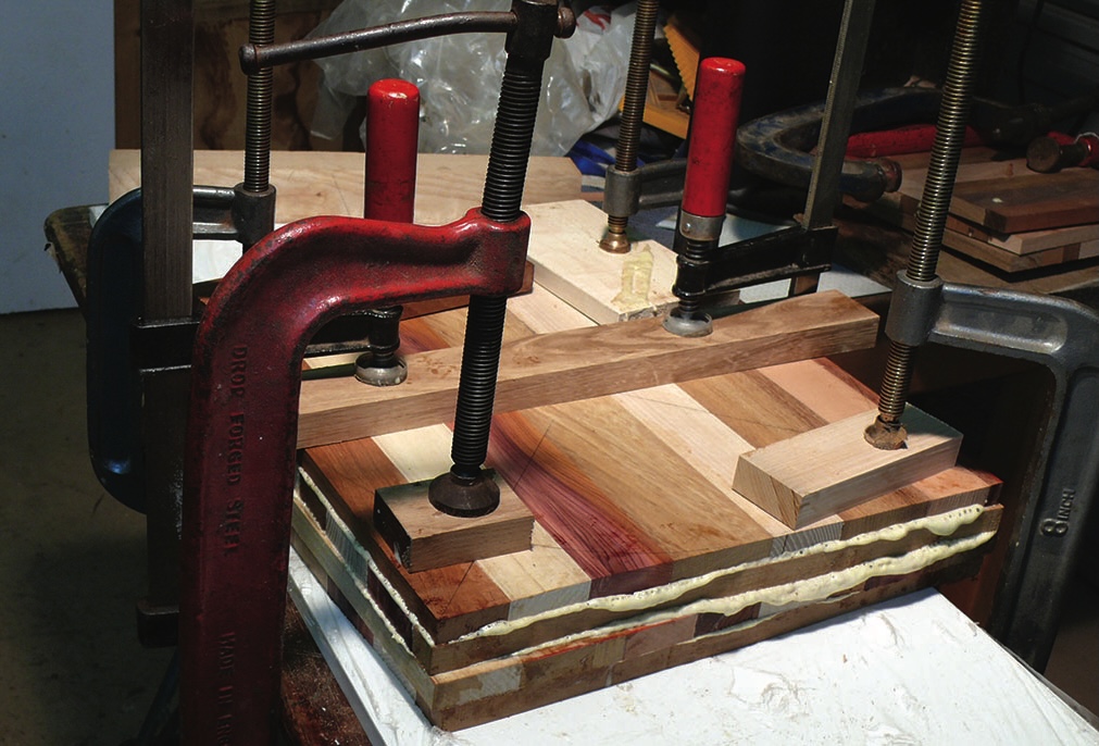 Wood glued and clamped for drying in workshop.