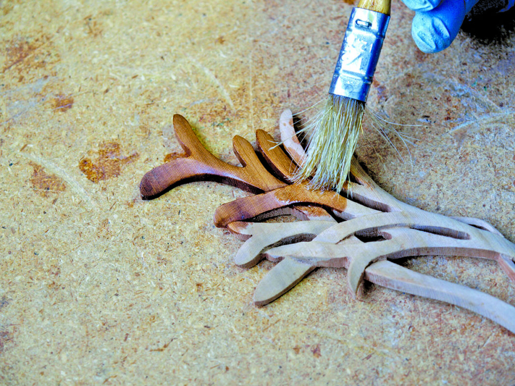 Applying varnish to wooden craft project