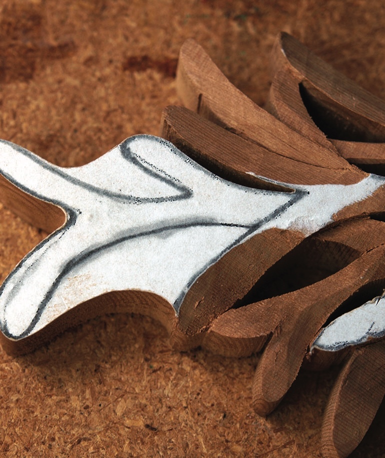 Wooden carved shape on cork background