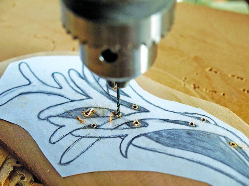 Drill creating holes in woodworking template.