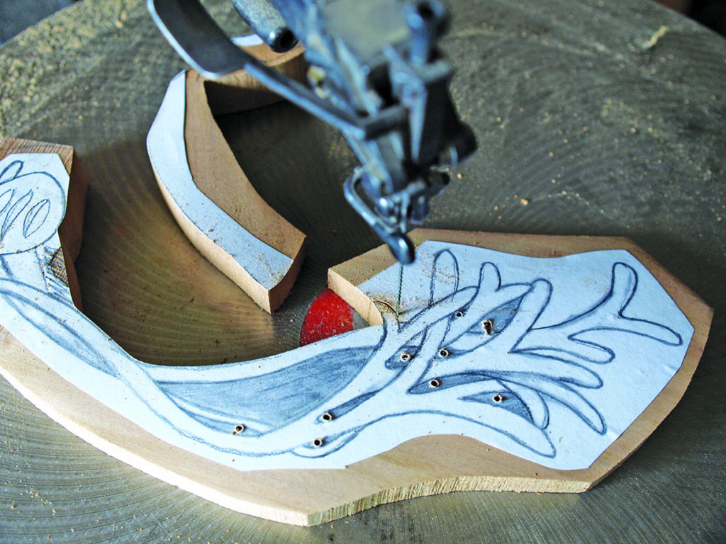 Scroll saw cutting intricate wood pattern