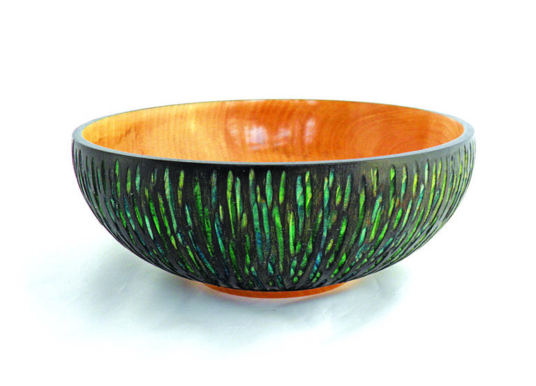 Wooden bowl with carved green accents.