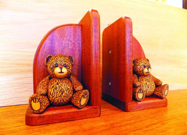 Wooden teddy bear bookends on shelf