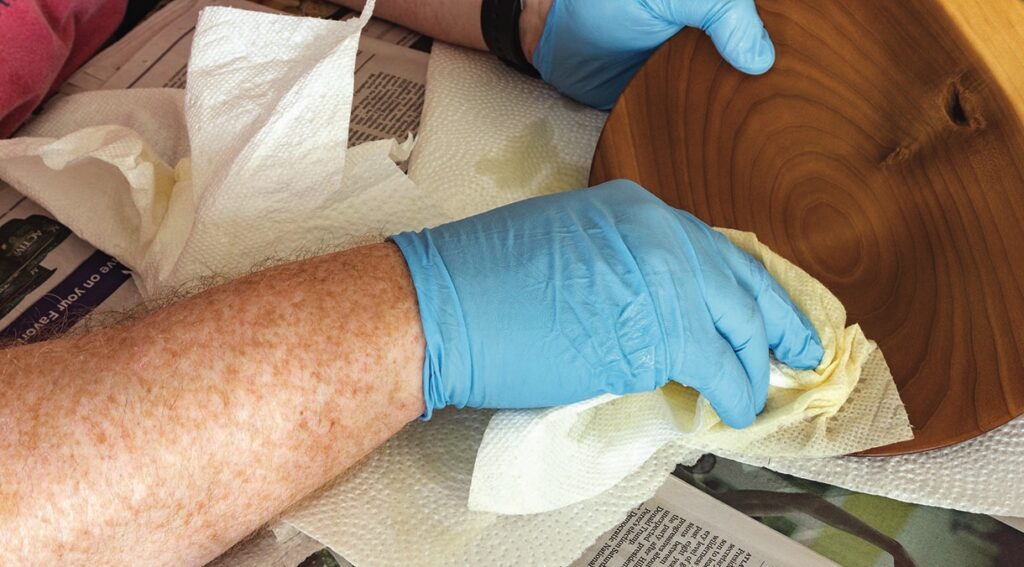 Polishing wood with gloves and paper towel