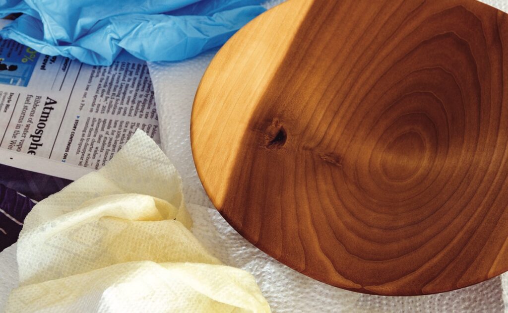 Wooden bowl with cleaning cloth and gloves.