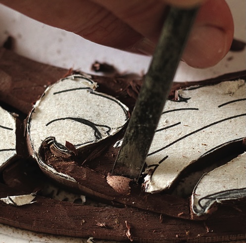 Close-up of carving wood with a chisel tool.