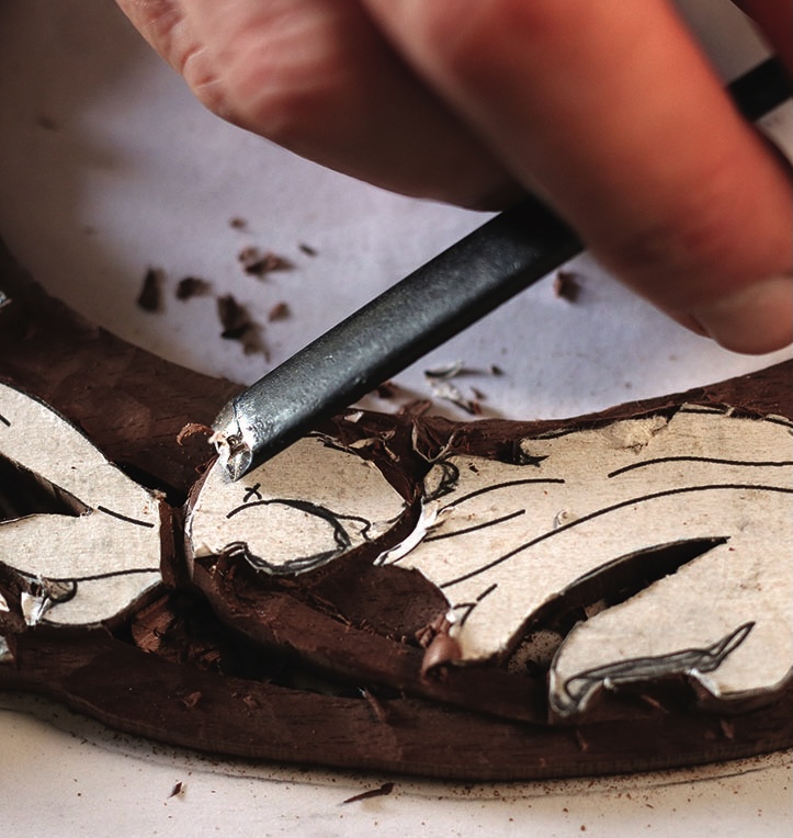 Carving wood with a detailed design template.