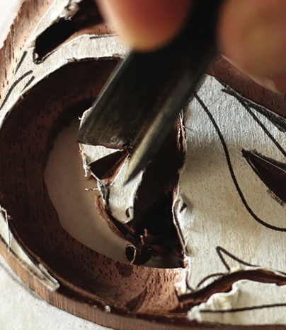 Close-up of woodcarving in progress with chisel.