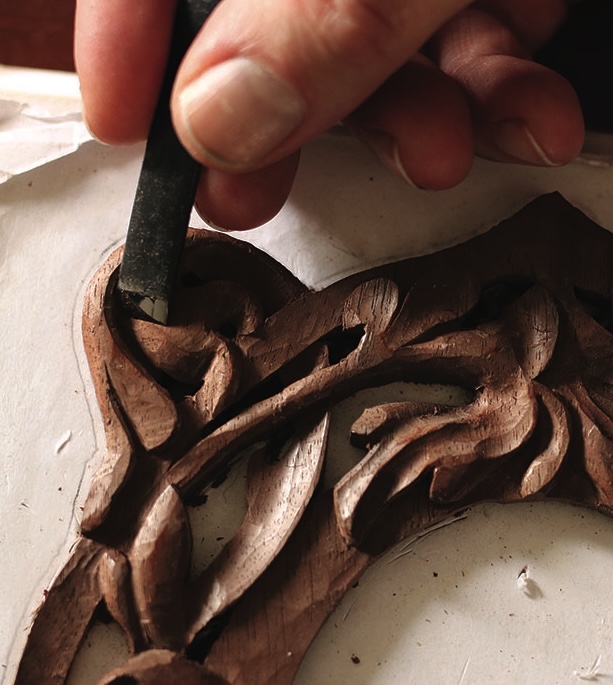 Wood carving in progress with chisel tool.