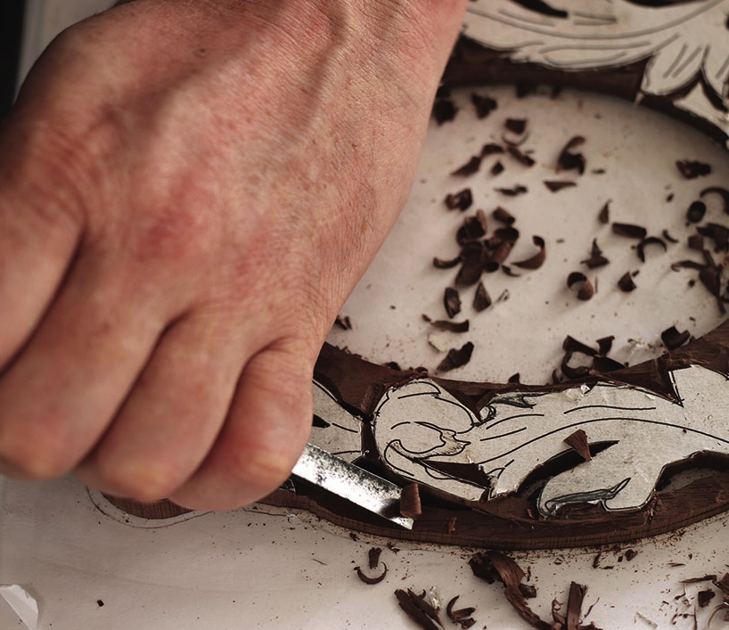 Hand carving intricate design into wood