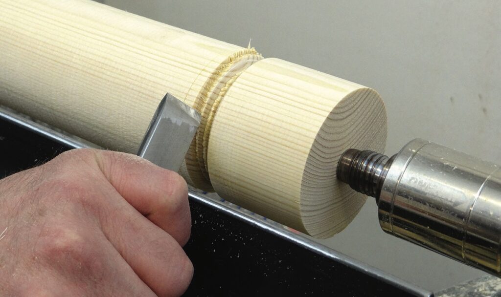 Woodturning with lathe and chisel tool.