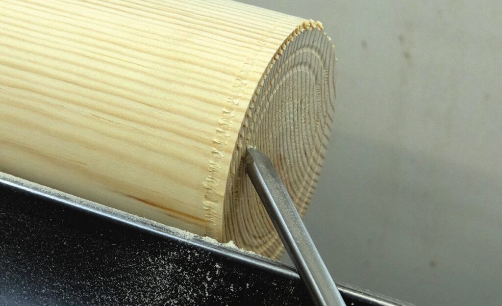 Turning wood on a lathe with chisel