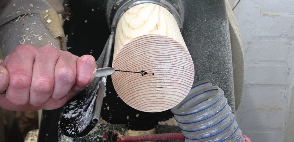 Person carving wood on lathe machine.
