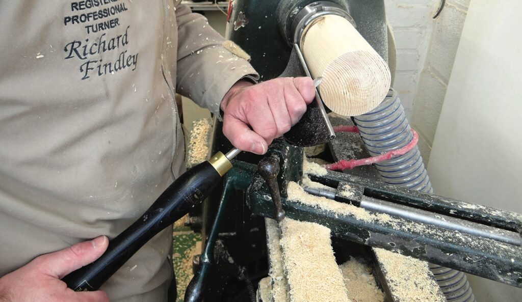 Woodturner carving on a lathe machine.