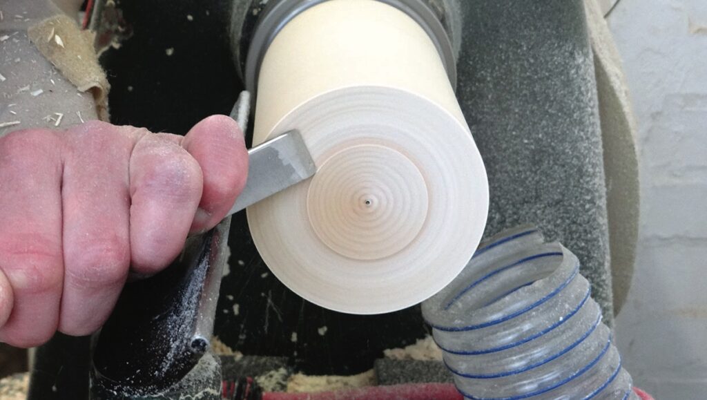 Hand turning wood on a lathe machine.