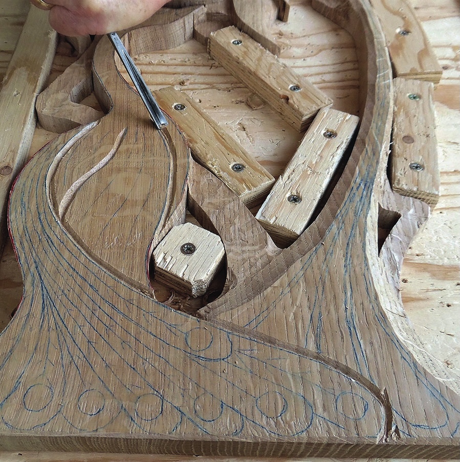 Wood carving in progress with intricate design details.