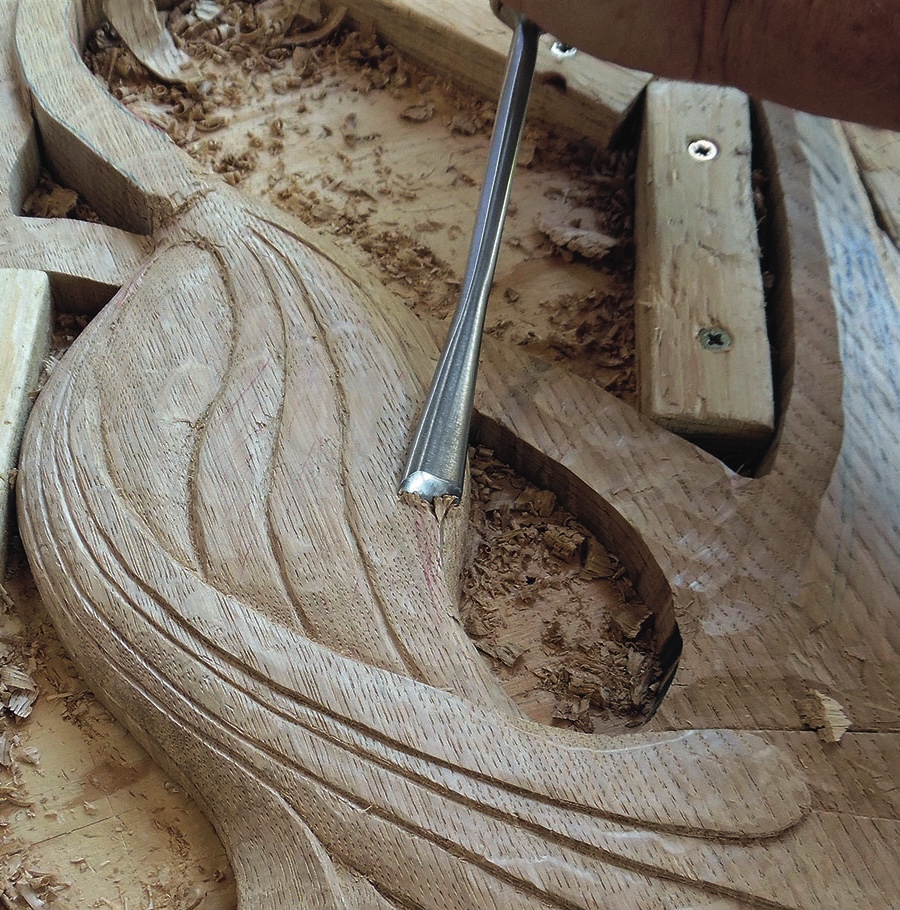Wood carving with chisel and shavings