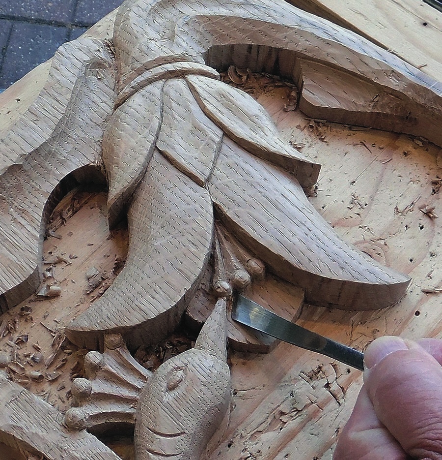Intricate wood carving with chisel, hand-crafted detail.