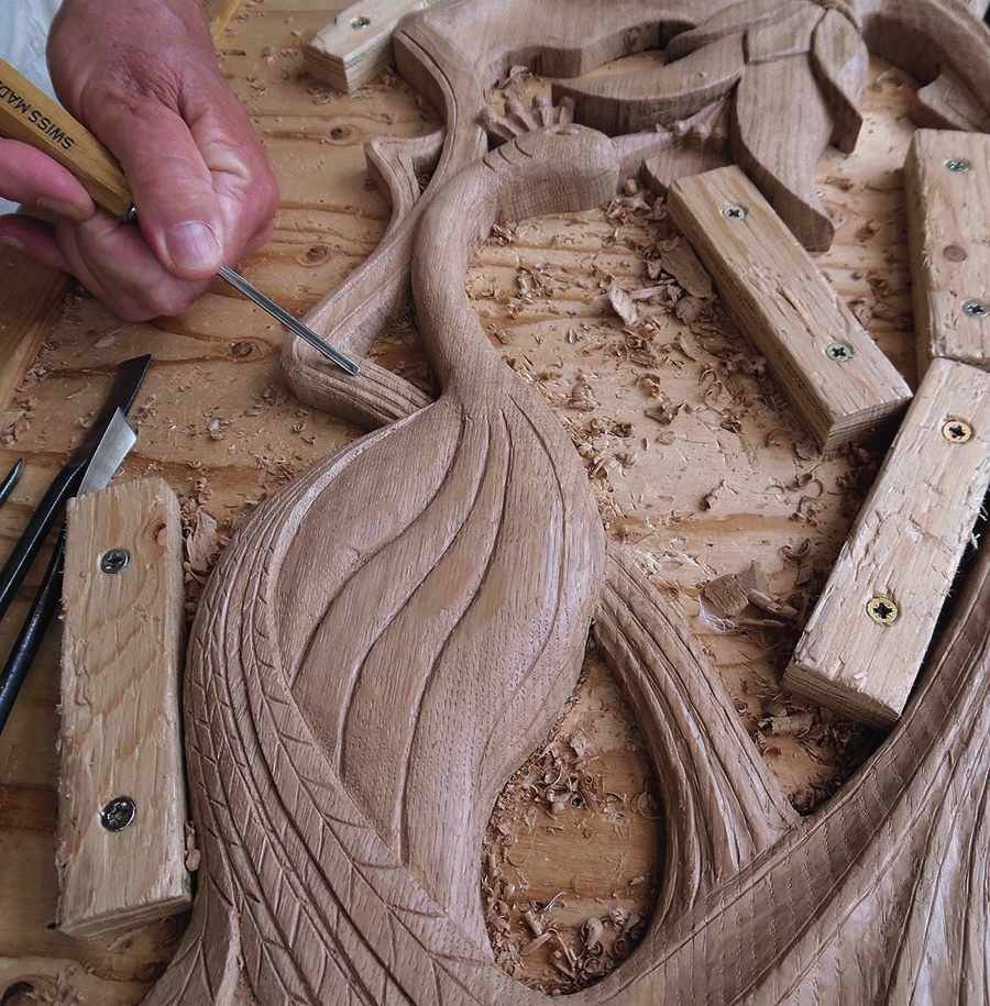 Wood carving in progress with hand tools.