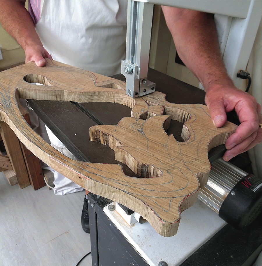 Person cutting wood with a bandsaw machine.