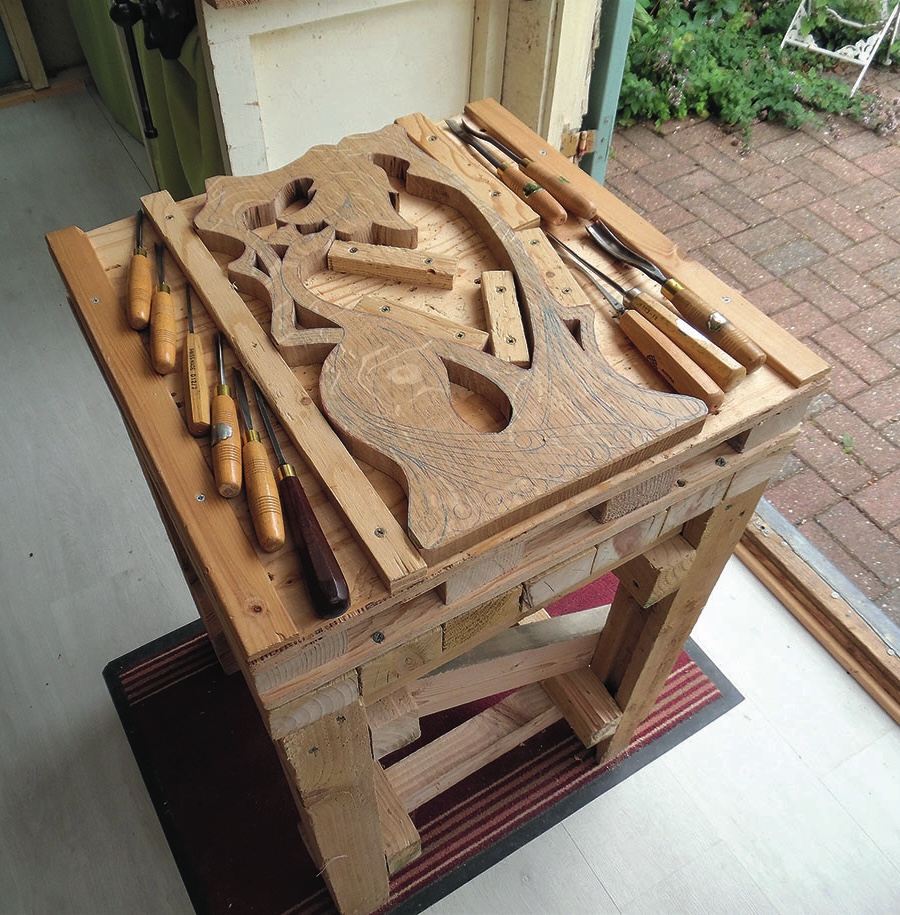 Wooden owl carving in a workshop with tools.