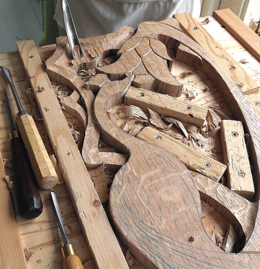 Wood carving with chisels on wooden table.