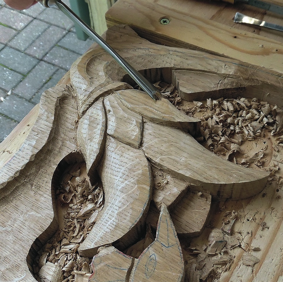 Wood carving in progress with carving tools.