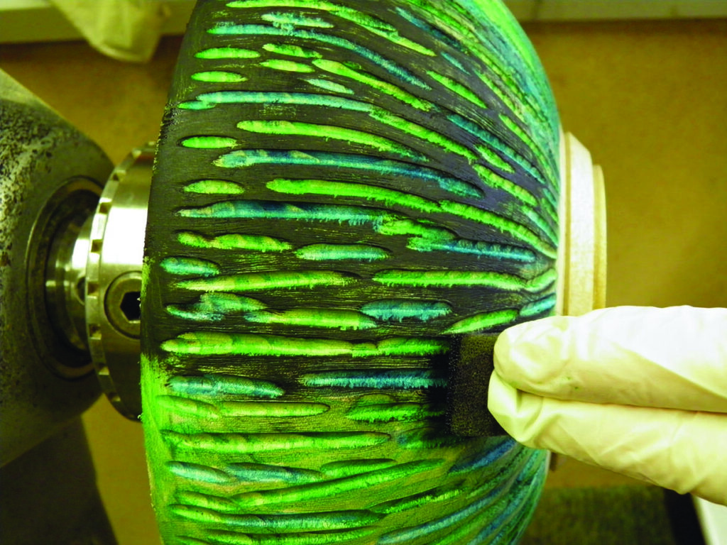 Applying colour to carved wooden bowl