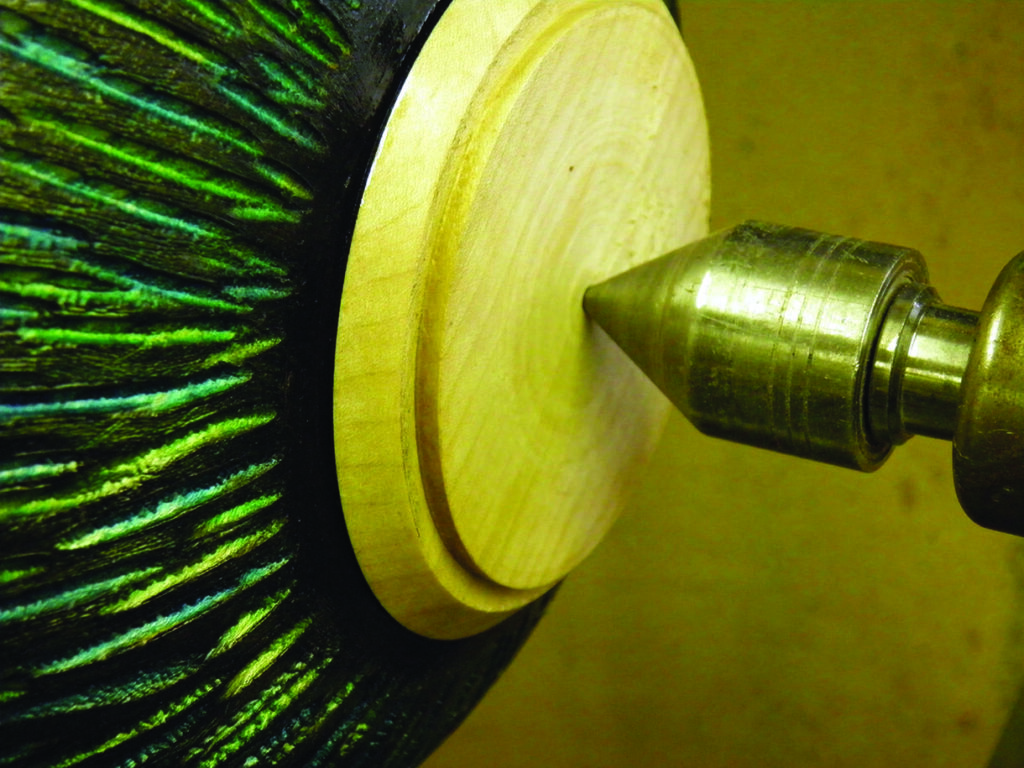 Wooden bowl being crafted on a lathe.