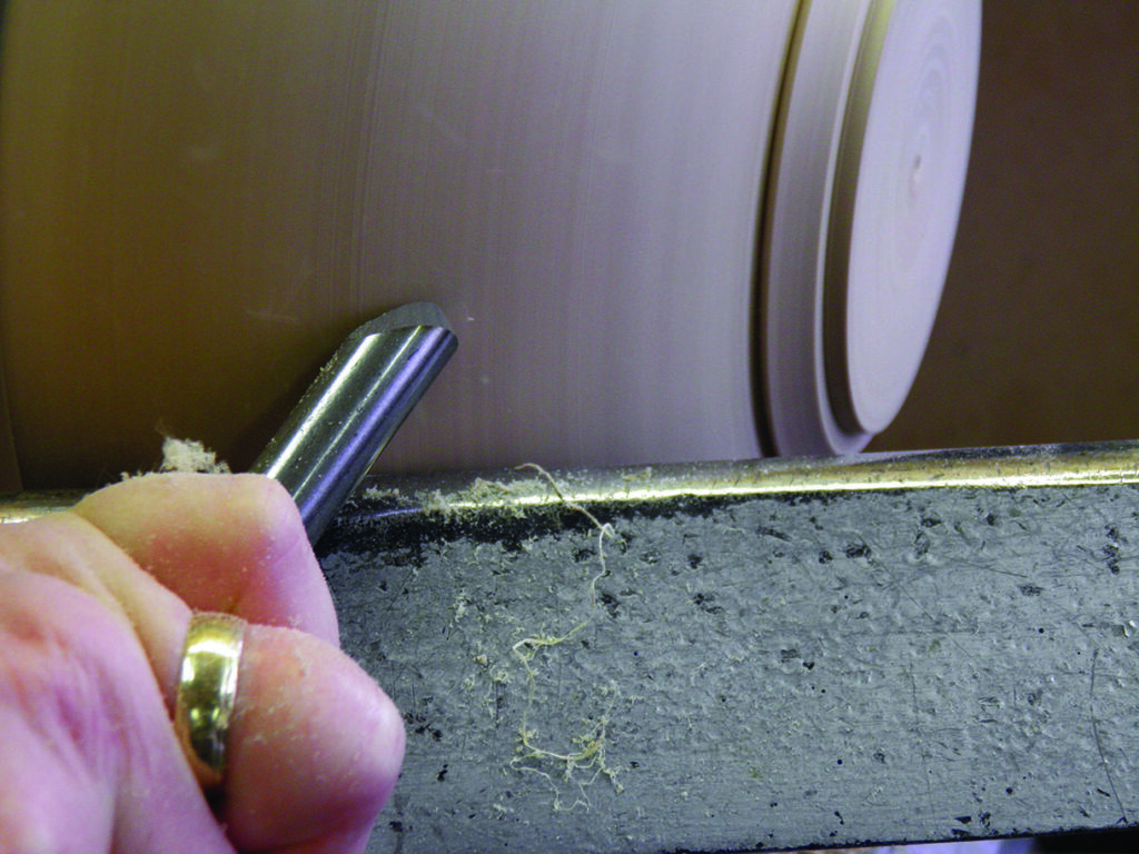Hand turning wood on a lathe.