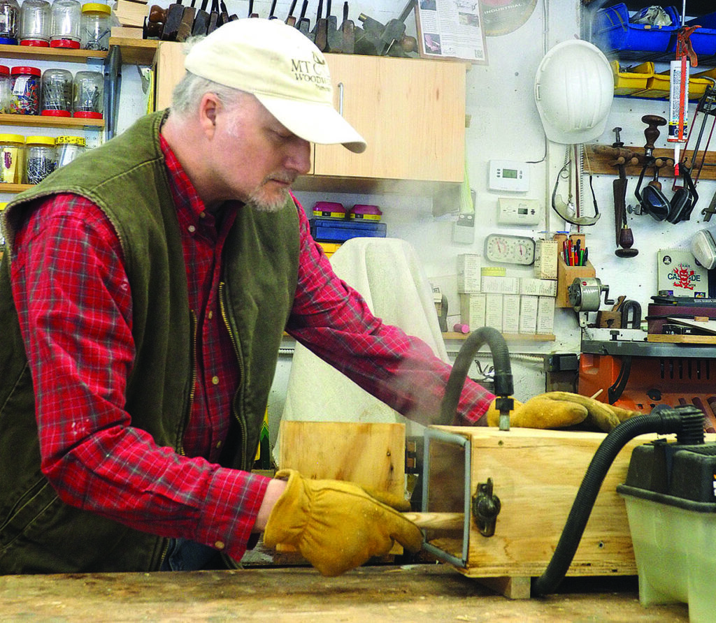 Man working with woodworking equipment in workshop