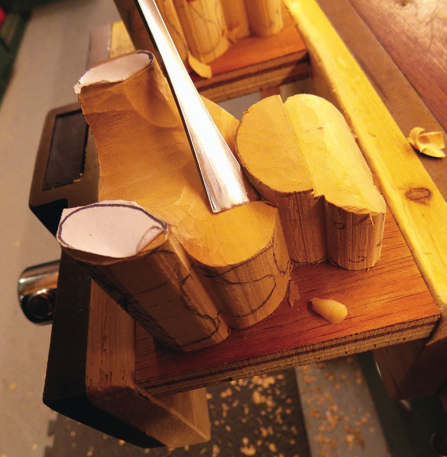 Wood carving in progress with carving tool.
