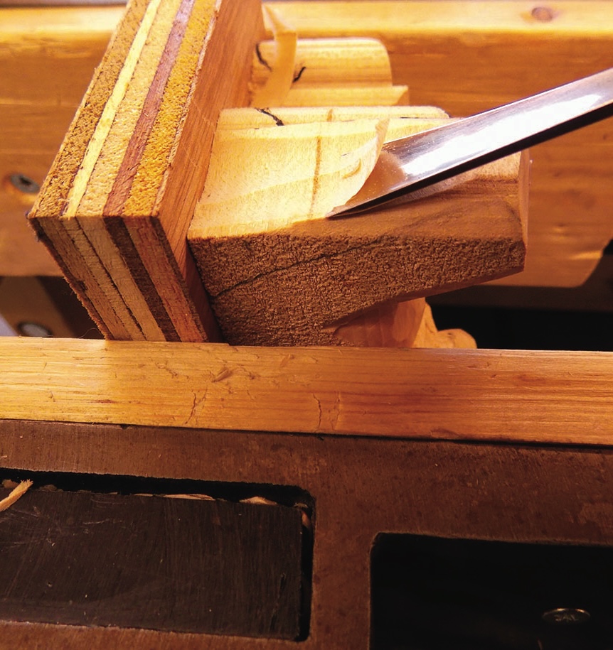 Chisel carving intricate wood joinery details.