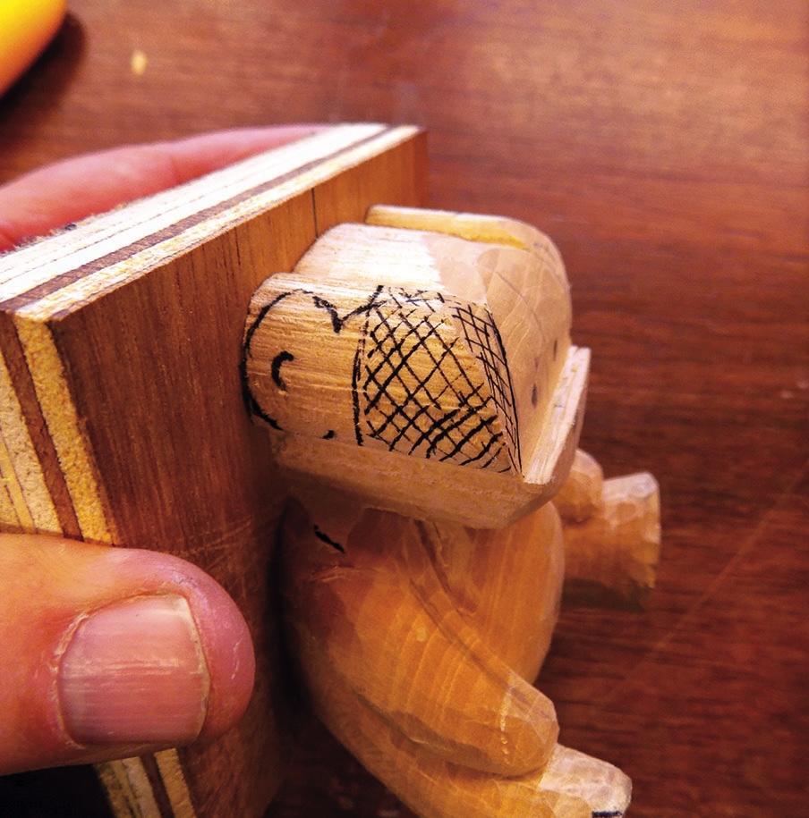 Wood carving of a partially sculpted bear.