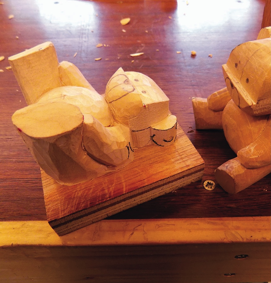 Wooden carved bear figures on a workbench