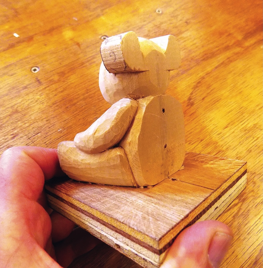 Hand-carved wooden bear figure on a base