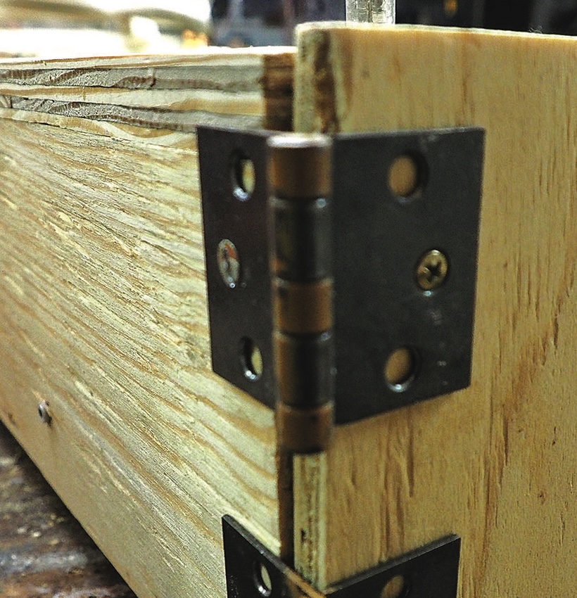 Close-up of a hinge on wooden corner joint.
