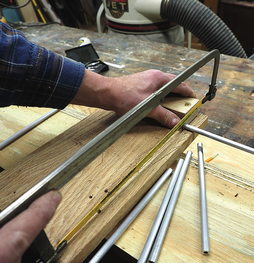 Person cutting aluminium rod with hacksaw